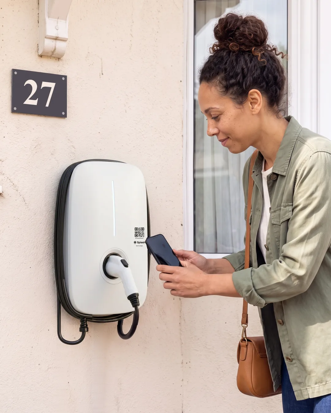 Maya holding her phone up to the code on Martin's charger.