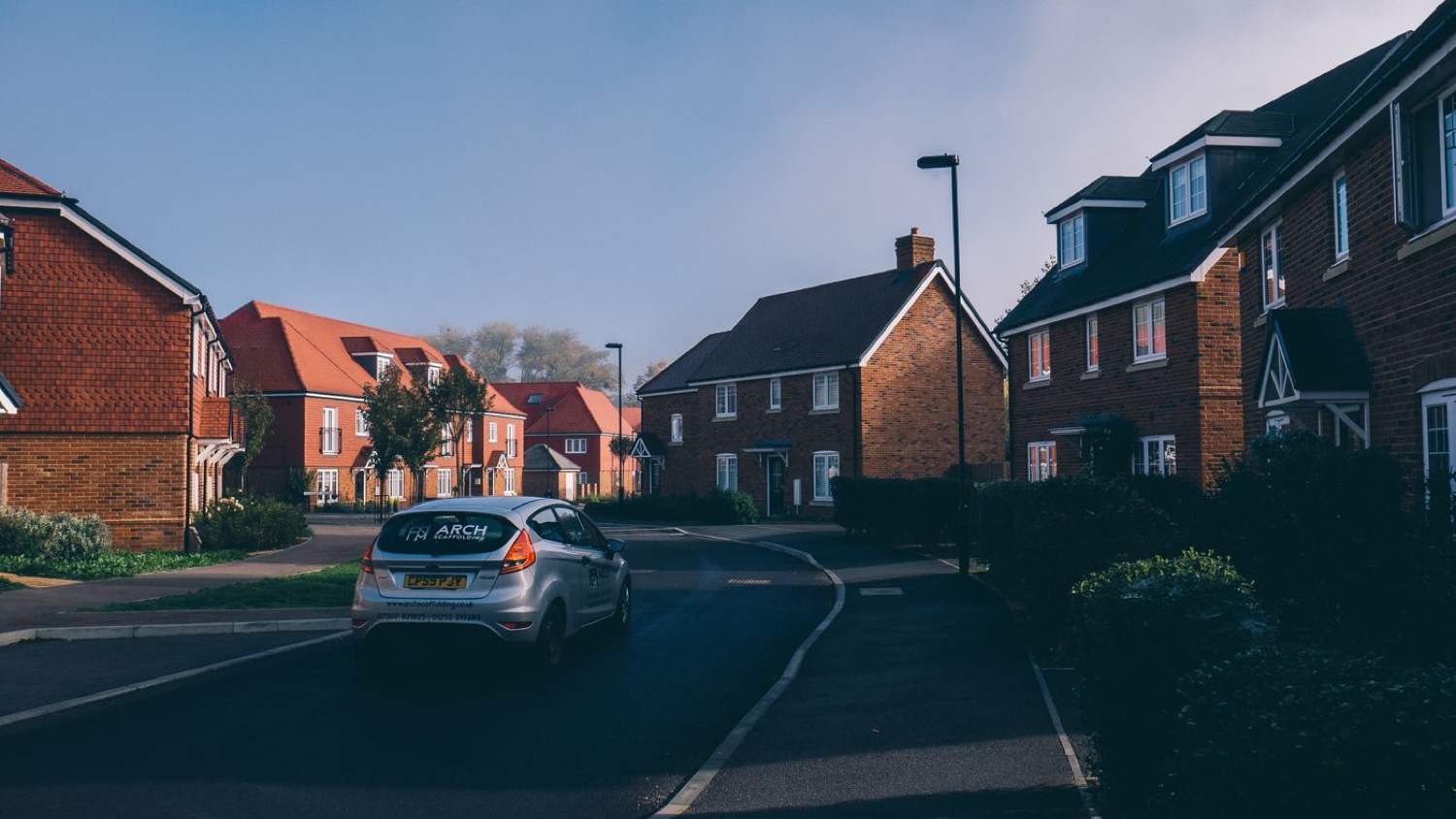 A quiet residential street lined with red-brick houses