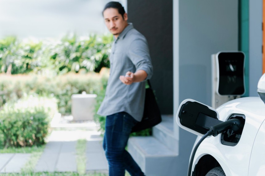 A host beside their home EV charger
