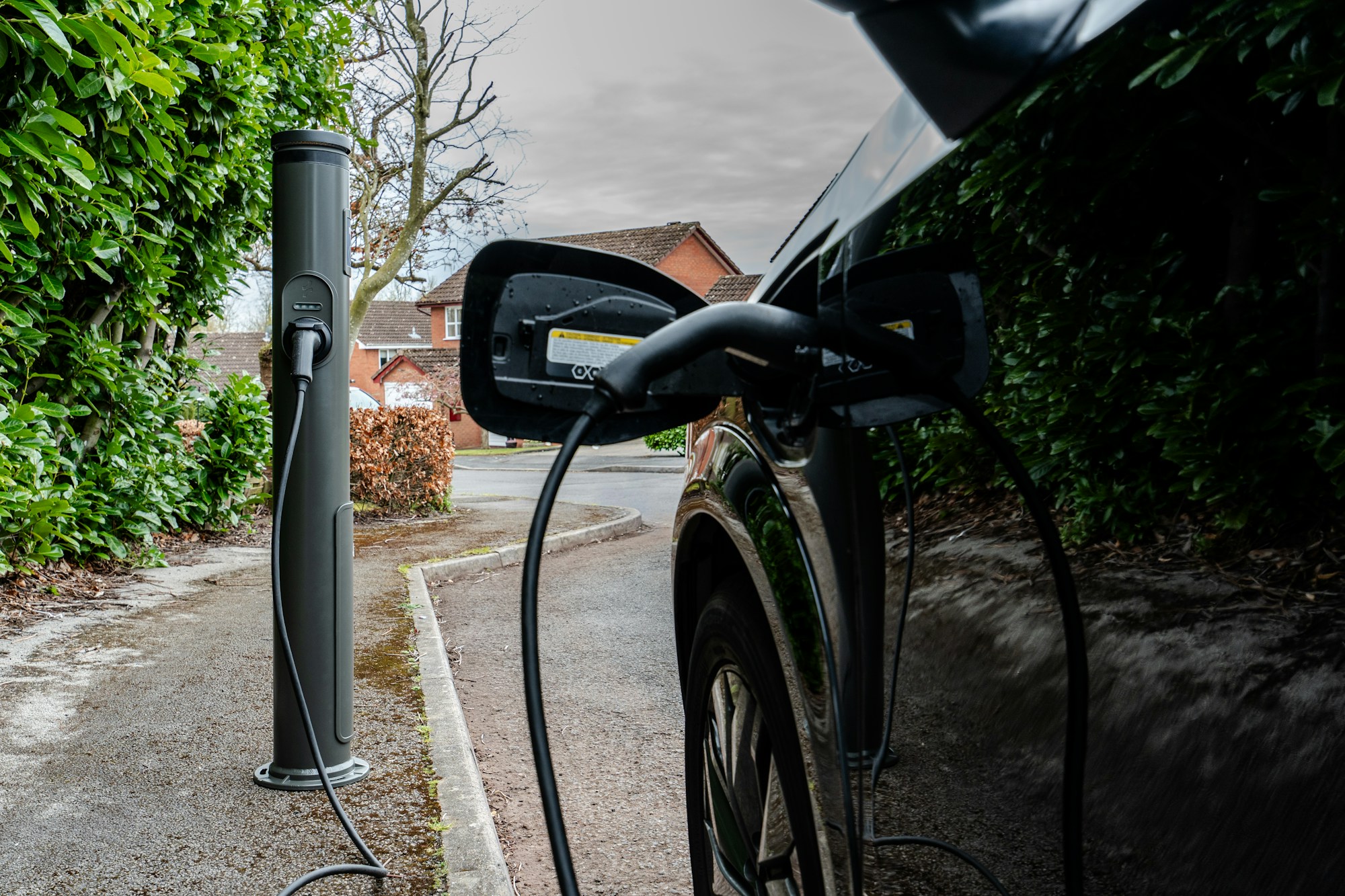 An EV plugged in at a kerbside charger on a quiet UK street